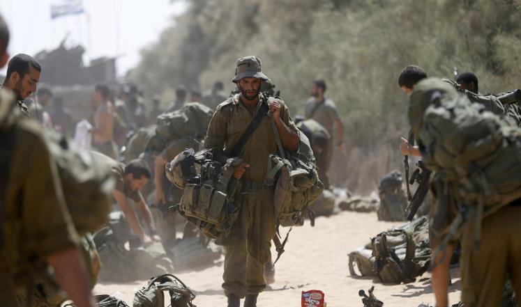 جندي إسرائيلي من لواء جفعاتي يحمل متعلقاته بعد عودته من غزة إلى إسرائيل (رويترز)