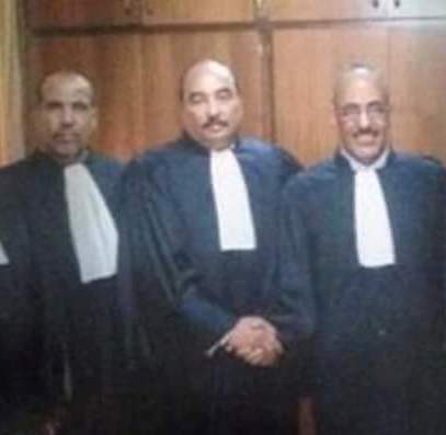الرئيس الموريتاني محمد ولد عبد العزيز (وسط) وهو يرتدي بدلة المحامين بعد إهدائها له من طرف نقيب المحامين الشيخ ولد حندي (يمين) خلال حفل افتتاح السنة القضائية