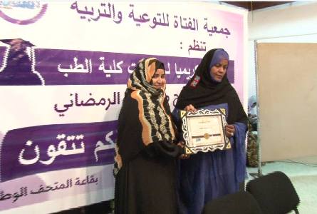 الأمين العامة لجمعية الفتاة زينب بنت الشيخ وهي تسلم وسام تكريم للدكتورة نسيبة بنت عبد القادر